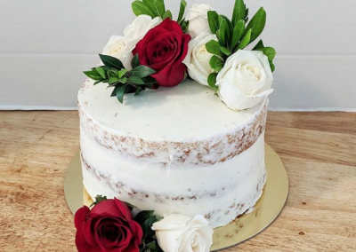 naked cake with fresh red and white roses