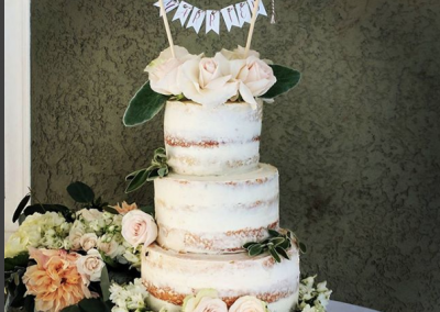 naked wedding cake with fresh flowers