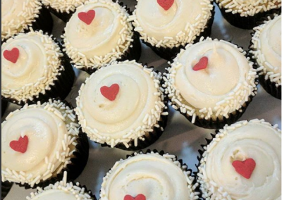white cupcakes with red hearts and white sprinkles